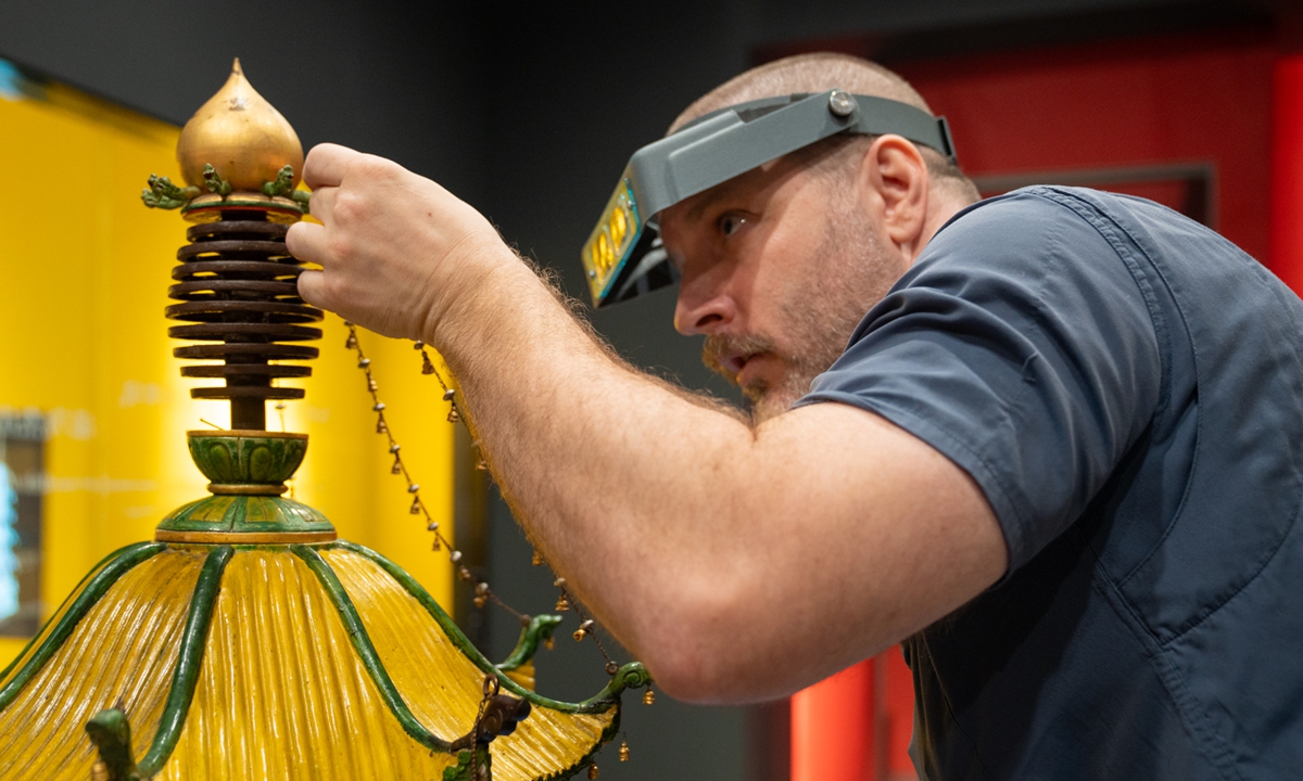 A staff member interact with the wooden model of Nanjing's lost Glazed Pagoda on September 19. Photo: Courtesy of the Nanjing's Great Bao'en Temple Ruins Museum