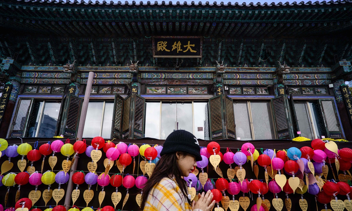 A South Korean woman prays at Bongeunsa Temple as students sit for the annual college entrance exam, known locally as Suneung, in Seoul, South Korea, on November 13, 2025. Photo: VCG