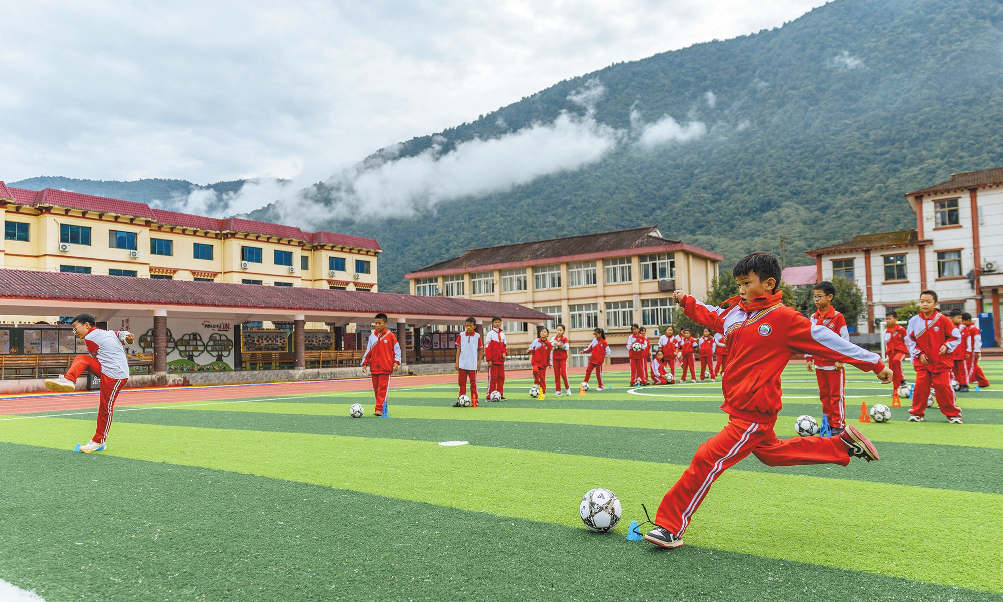 Children play football at Medog Elementary School in October 2025.