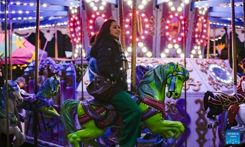 A visitor enjoys a merry-go-round at the Vancouver Christmas Market in Vancouver, British Columbia, Canada, Nov. 14, 2025. The annual festive event features more than 110 wooden huts offering various handicrafts, traditional European food, drink, and souvenirs, along with live performances. This year's market opened here on Thursday and will run until Dec. 24. Photo: Xinhua