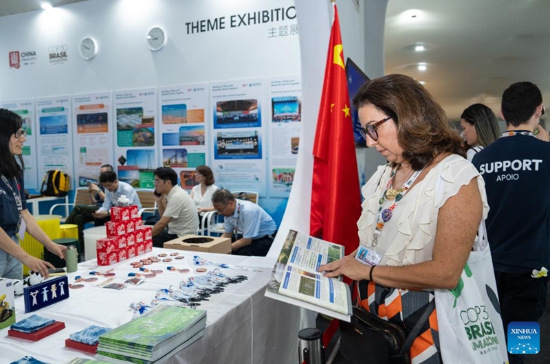 A guest reads a brochure at the China Pavilion during the 30th United Nations climate change conference in Belem, Brazil, Nov. 12, 2025. The 30th United Nations climate change conference, commonly known as COP30, opened Monday in Belem, Brazil. Displays of Chinese cultural products, green technologies, and innovations attracted attention of the attendees during the conference. Photo: Xinhua