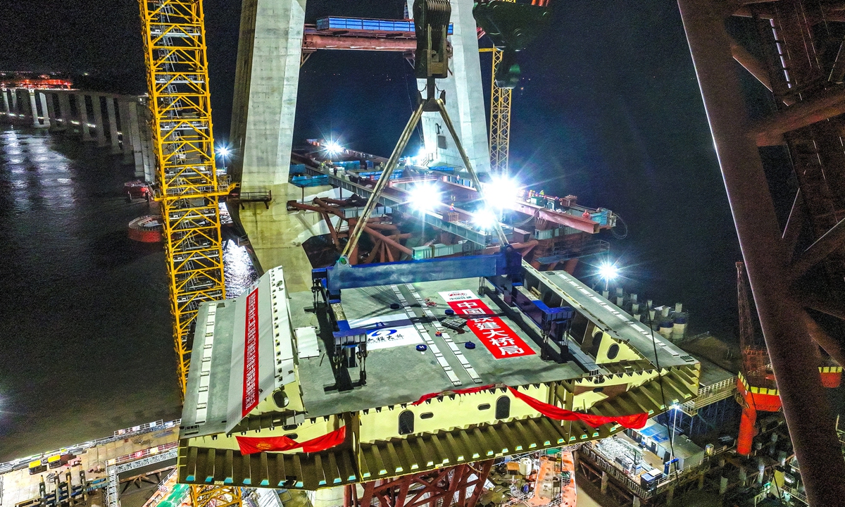 A 1,200-ton large floating crane ship successfully lifts and places a steel box girder (numbered EA2) onto the Qinglongmen Bridge on November 16, 2025 in Zhoushan, East China's Zhejiang Province. This operation signifies the start of the superstructure construction of the bridge, laying a crucial foundation for the subsequent completion of the project. Photo: VCG