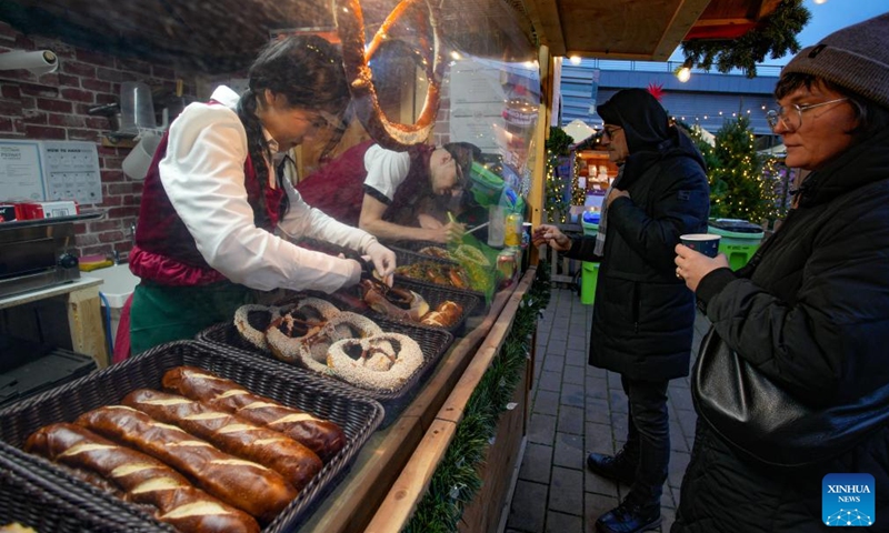 Vendors work at a wooden hut selling food at the Vancouver Christmas Market in Vancouver, British Columbia, Canada, Nov. 14, 2025. The annual festive event features more than 110 wooden huts offering various handicrafts, traditional European food, drink, and souvenirs, along with live performances. This year's market opened here on Thursday and will run until Dec. 24. Photo: Xinhua