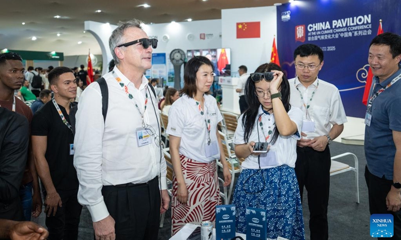 Guests try a China-made smart device at the China Pavilion during the 30th United Nations climate change conference in Belem, Brazil, Nov. 12, 2025. The 30th United Nations climate change conference, commonly known as COP30, opened Monday in Belem, Brazil. Displays of Chinese cultural products, green technologies, and innovations attracted attention of the attendees during the conference. Photo: Xinhua