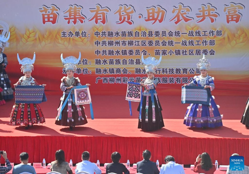 Actresses display embroideries and brocades of Miao ethnic group at an agricultural fair in Rongshui Miao Autonomous County, south China's Guangxi Zhuang Autonomous Region, Nov. 15, 2025. A Miao town community of Rongshui County held this fair to showcase and promote agricultural specialties and intangible cultural heritage from neighboring townships. Photo: Xinhua