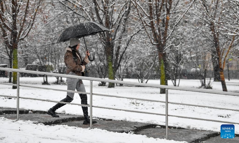 A woman walks in snow in Moscow, Russia, on Nov. 15, 2025. Moscow on Friday saw its first snowfall since the beginning of winter this year. Photo: Xinhua