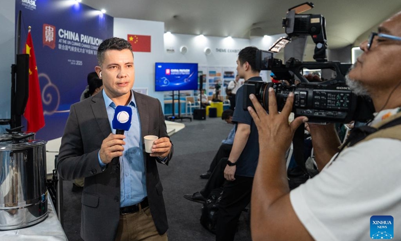 A journalist covers Chinese tea at the China Pavilion during the 30th United Nations climate change conference in Belem, Brazil, Nov. 12, 2025. The 30th United Nations climate change conference, commonly known as COP30, opened Monday in Belem, Brazil. Displays of Chinese cultural products, green technologies, and innovations attracted attention of the attendees during the conference. Photo: Xinhua