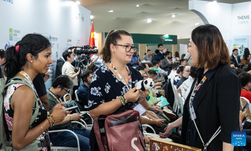 A guest receives a toy panda at the China Pavilion during the 30th United Nations climate change conference in Belem, Brazil, Nov. 12, 2025. The 30th United Nations climate change conference, commonly known as COP30, opened Monday in Belem, Brazil. Displays of Chinese cultural products, green technologies, and innovations attracted attention of the attendees during the conference. Photo: Xinhua