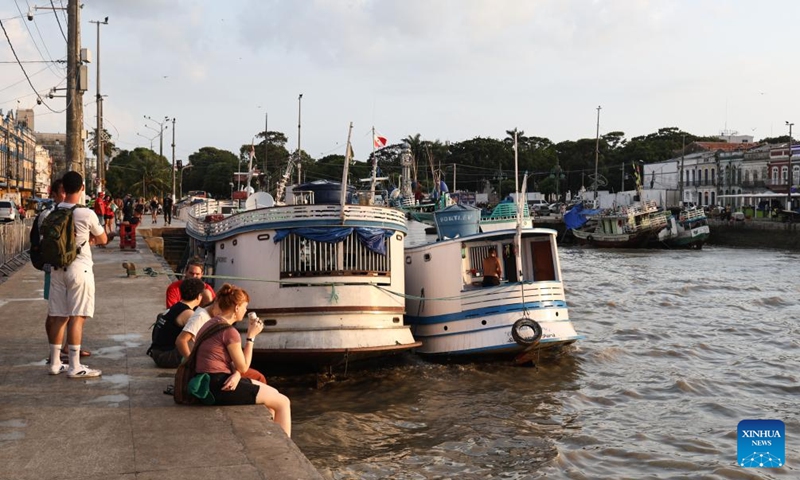 People relax by the riverside in Belem, Brazil, Nov. 16, 2025. (Photo by Claudia Martini/Xinhua)