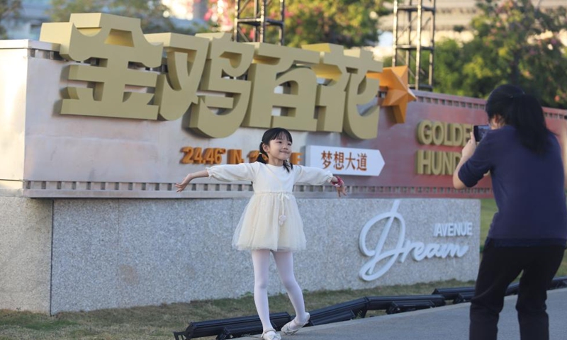 A girl poses for a photo at the Dream Avenue of the Golden Rooster and Hundred Flowers in Xiamen, southeast China's Fujian Province, Nov. 16, 2025. The avenue opened to public on Sunday. (Photo by Zeng Demeng/Xinhua)