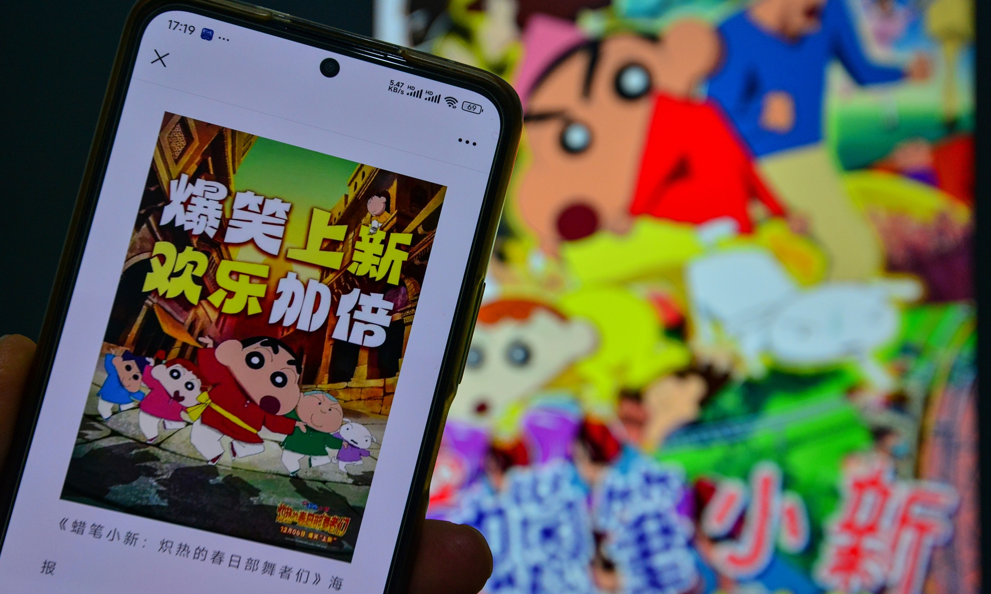 A poster of the Japanese film <em>Crayon Shin-chan the Movie: Super Hot! Scorching Kasukabe Dancers</em> is displayed on the smartphones of citizens in Fuyang, Anhui Province on November 17, 2025. Photo: VCG