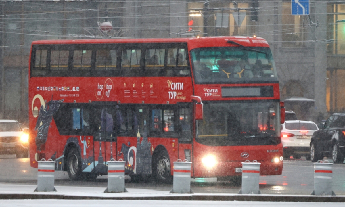 A city tour bus drives on a street during a snowfall, in Saint Petersburg, Russia on November 18. Photo: VCG