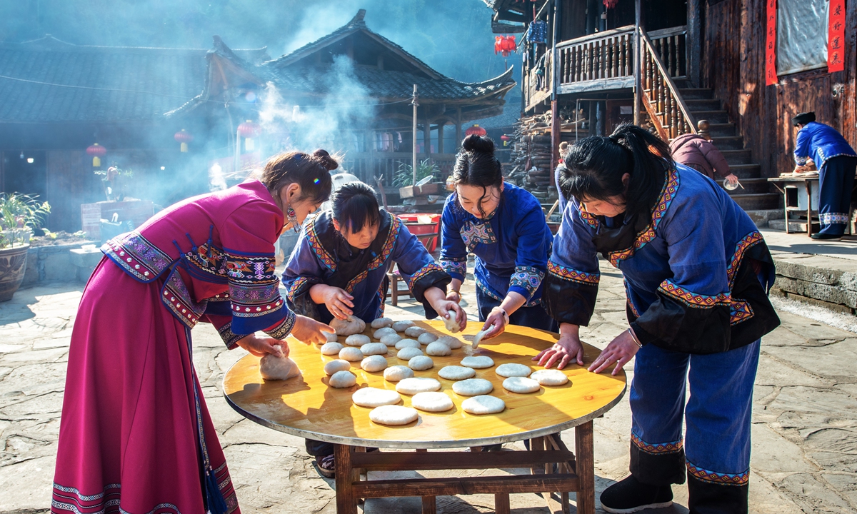 Locals make Ciba, a traditional Chinese cake made from pressed sticky rice, in Shuangfeng Villag.