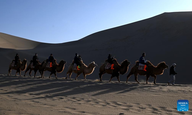 Tourists visit the Mingsha Mountain and Crescent Spring Scenic Area in Dunhuang City, northwest China's Gansu Province, on Nov. 22, 2025. Photo: Xinhua