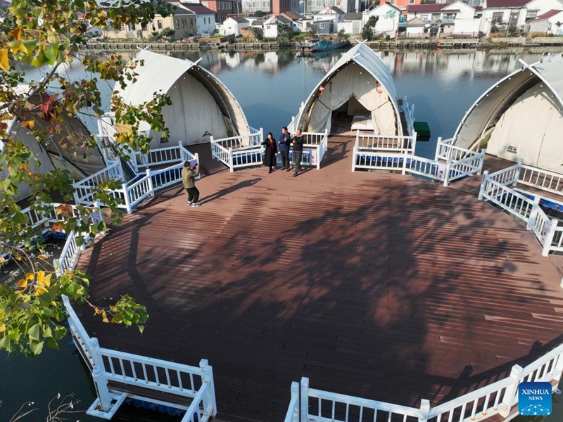 An aerial drone photo taken on Nov. 21, 2025 shows people posing for photos at a waterfront homestay in Chenyang Village of Xinghua, east China's Jiangsu Province. Local authorities in Xinghua have sought to embed environmental construction into the rural industry landscape in recent years, helping create numerous villages that are both livable and suitable for business operations. Photo: Xinhua