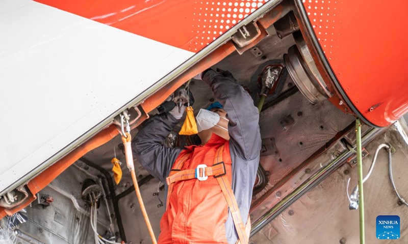 A staff member of the Grand China Aviation Maintenance Co., Ltd. under the HNA Technic performs maintenance on an aircraft at the Hainan Free Trade Port (FTP) One-Stop Aircraft Maintenance Base in Haikou, south China's Hainan Province, on Nov. 21, 2025. The Hainan Free Trade Port (FTP) One-Stop Aircraft Maintenance Base, which started operation in 2022, has performed maintenance service on more than 2,400 aircraft, completed full-body painting for over 280 aircraft, and repaired about 60,000 aircraft components as of the end of October this year.
The maintenance base has drawn global clients like Qatar Airways, Royal Air Philippines and Iberia.
Under the Hainan FTP's favorable regulations, aircraft entering the region for maintenance are exempt from paying security deposits, and parts imported for repair benefit from a bonded status. The policy support is expected to be amplified following the FTP's official launch of island-wide independent customs operations on Dec. 18. Photo: Xinhua