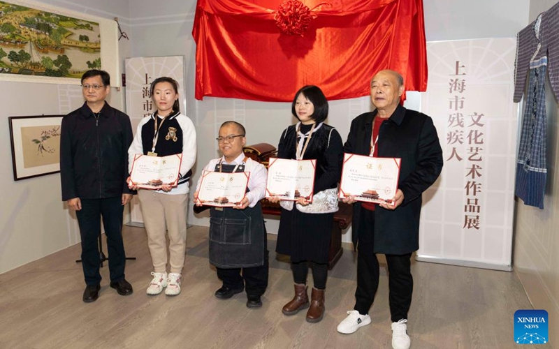 Representatives of disabled artists pose for a group photo during an exhibition held at the Sensory Experience Gallery of the Palace Museum in Beijing, capital of China, Nov. 21, 2025. Featuring artworks created by disabled artists from Shanghai, the exhibition kicked off here on Friday. Under the guidance of inheritors of intangible cultural heritages, these artists infused their love for life and reverence for culture into their works. Photo: Xinhua