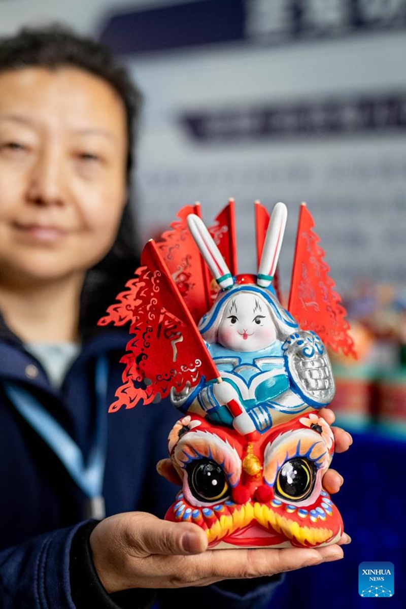 A staff member displays a Lord Rabbit, known as Tu'er Ye in Chinese (a traditional handicraft and a festive clay toy for children, especially in Beijing), during a promotion week for intangible cultural heritage brands in Dali, southwest China's Yunnan Province, Nov. 23, 2025. More than 120 brands of intangible cultural heritage took part in the brand promotion week which opened here on Sunday. Photo: Xinhua