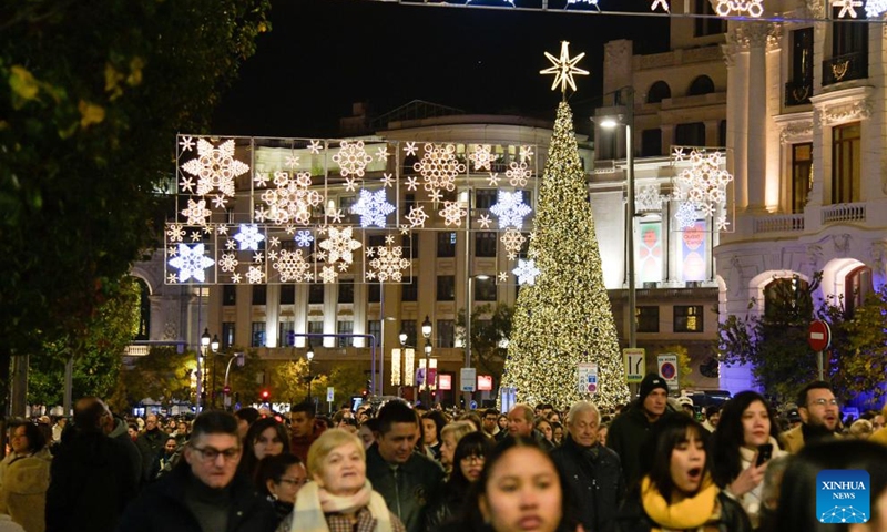 People enjoy the festive light on a street in Madrid, Spain, Nov. 22, 2025. Madrid held a Christmas light-up ceremony on Saturday with a projection light show. (Xinhua/Cheng Min)