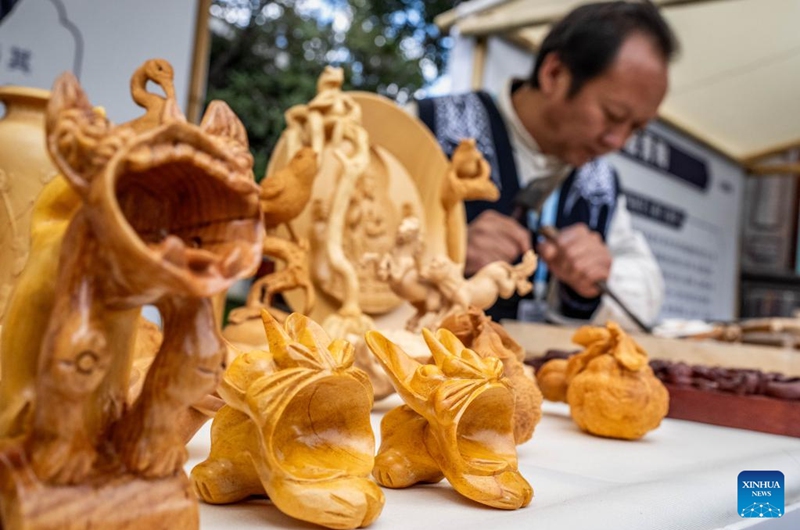 Yang Huanpei, a provincial-level inheritor for Jianchuan Wood Carving, demonstrates his skills during a promotion week for intangible cultural heritage brands in Dali, southwest China's Yunnan Province, Nov. 23, 2025. More than 120 brands of intangible cultural heritage took part in the brand promotion week which opened here on Sunday.  Photo: Xinhua
