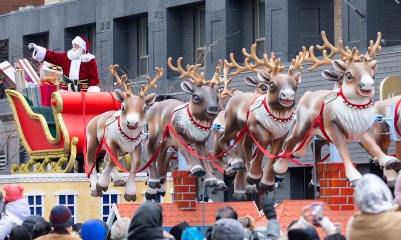 A man dressed as Santa Claus waves to crowds during the 2025 Original Santa Claus Parade in Toronto, Canada, on Nov. 23, 2025. Featuring dozens of themed floats and marching bands, the annual parade was held here on Sunday. (Photo by Zou Zheng/Xinhua)