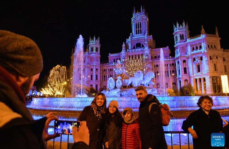 People pose for a group photo in front of the Cibeles Palace in Madrid, Spain, Nov. 22, 2025. Madrid held a Christmas light-up ceremony on Saturday with a projection light show. (Xinhua/Cheng Min)