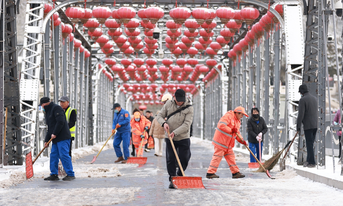 Sanitation workers clear snow from the road in Lanzhou, Northwest China's Gansu Province, on November 24, 2025. The city witnessed its first snowfall since the start of the winter in 2025 that day. Photo: VCG