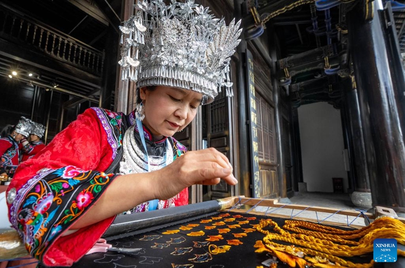 Chen Guotao, a city-level inheritor for Miao Embroidery, shows her skills during a promotion week for intangible cultural heritage brands in Dali, southwest China's Yunnan Province, Nov. 23, 2025. More than 120 brands of intangible cultural heritage took part in the brand promotion week which opened here on Sunday. Photo: Xinhua