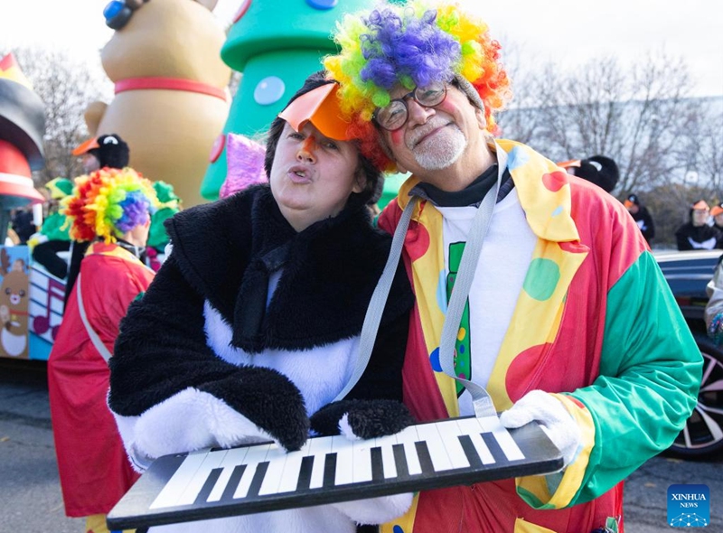 Dressed-up paraders pose for photos during the 2025 Original Santa Claus Parade in Toronto, Canada, on Nov. 23, 2025. Featuring dozens of themed floats and marching bands, the annual parade was held here on Sunday. (Photo by Zou Zheng/Xinhua)