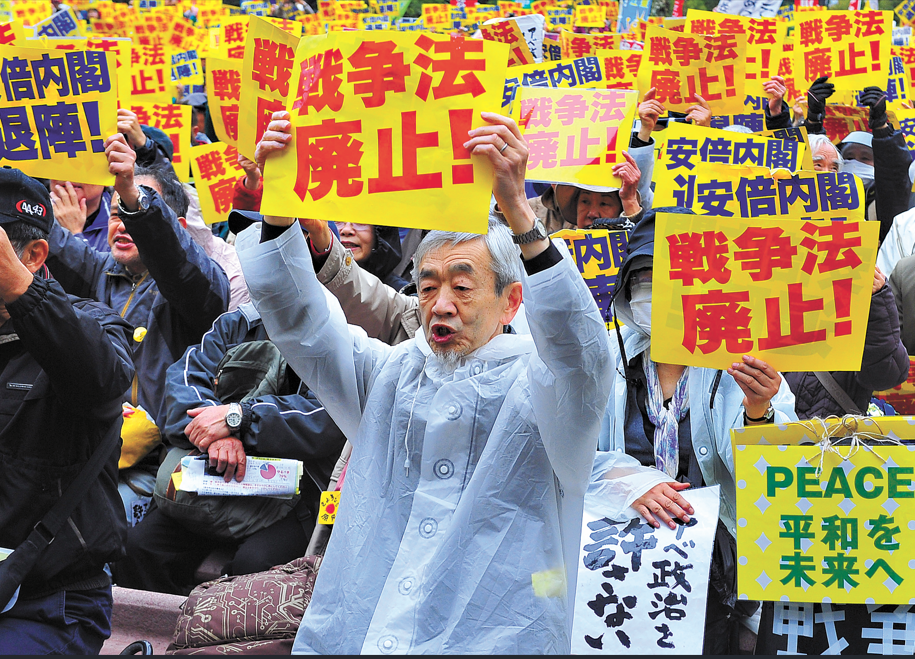 A large crowd of Japanese citizens gathers in Hibiya Park, holding a rally in the rain to vehemently demand the abolition of the new security legislation in Tokyo, Japan, on March 19, 2016. Photo: CNS