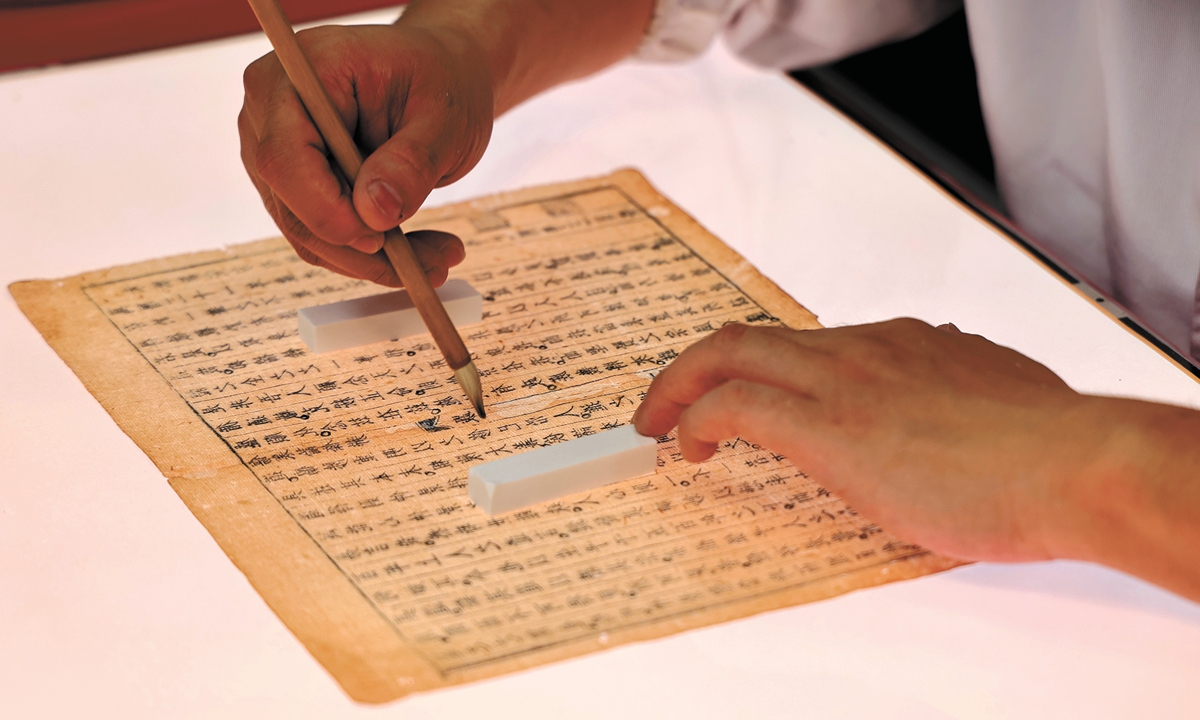 An ancient book restorer repairs damaged pages of traditional Chinese medicine (TCM) manuscripts in Anhui Province in September, 2025. Photo: VCG