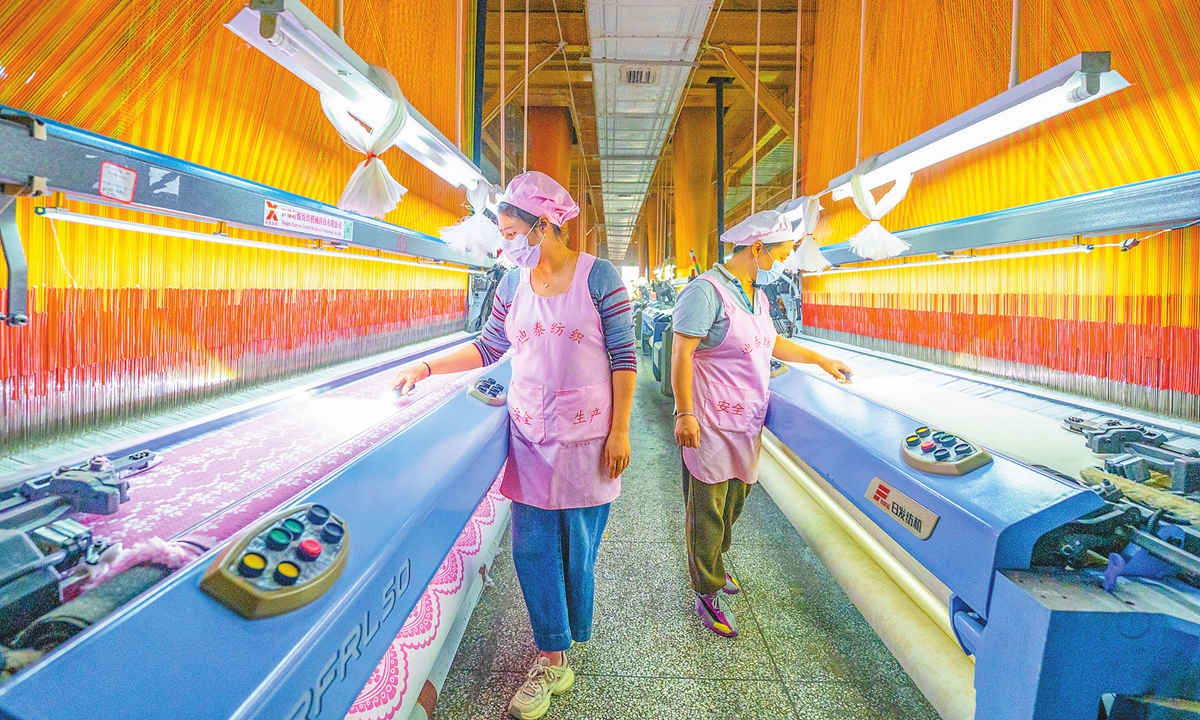 Workers fill orders for jacquard fabrics destined for export at a textile company in Nantong, East China's Jiangsu Province on November 26, 2025. The city has actively promoted industrial transformation by implementing technology upgrades, enhancing market competitiveness, and maintaining strong momentum in high-quality development. Photo: VCG