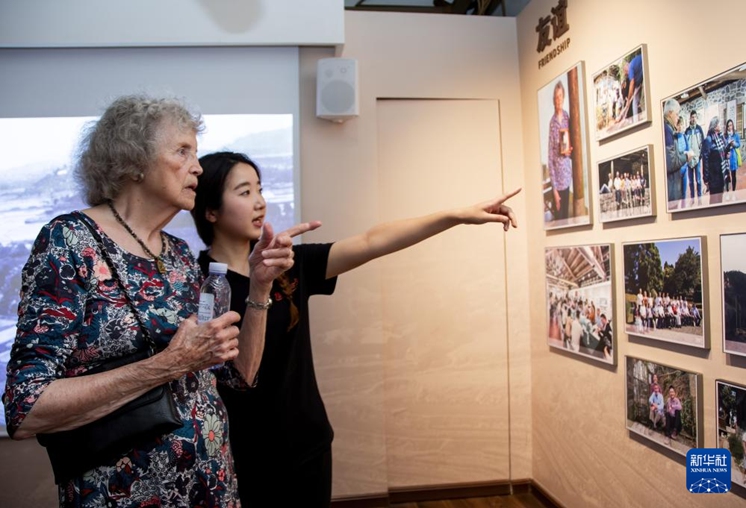 Gail Harris, (left), a member of the Friends of Guling, views historical photos of her family at the Guling Stories Exhibition Hall on June 22, 2024. (Photo by Wei Peiquan/Xinhua)
