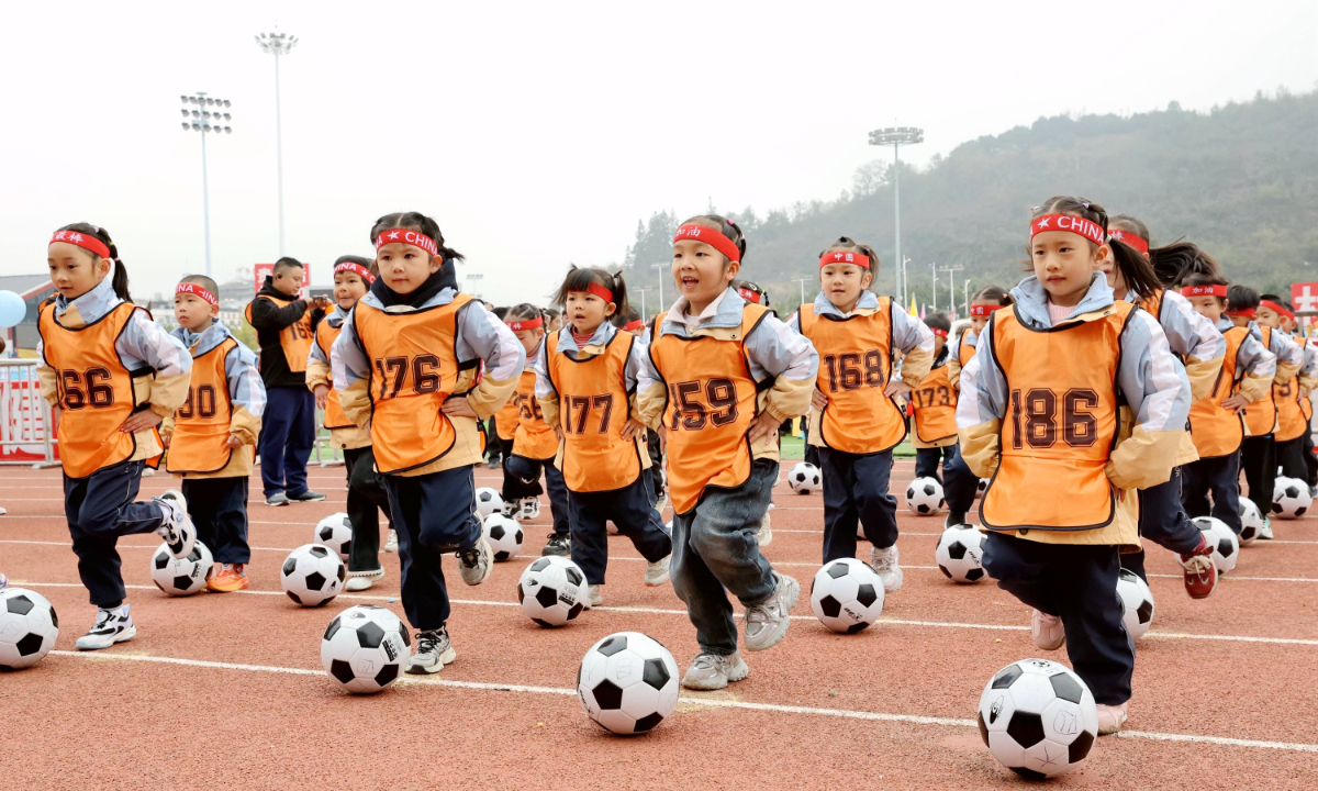 Kindergarten children perform a football exercise routine at the 11th parent-child winter games held at the football field of the Village Super League in Rongjiang county, the Qiandongnan Miao and Dong autonomous prefecture in Southwest China's Guizhou Province, on November 27, 2025. Photo: VCG