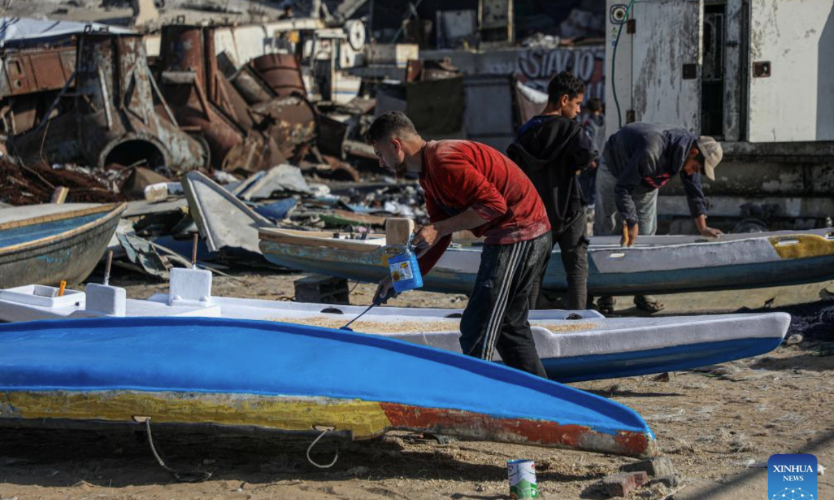Palestinians repair a fishing boat destroyed during the Israeli war on the Gaza Strip, inside the seaport in west of Gaza City, on Nov. 27, 2025. (Photo by Rizek Abdeljawad/Xinhua)