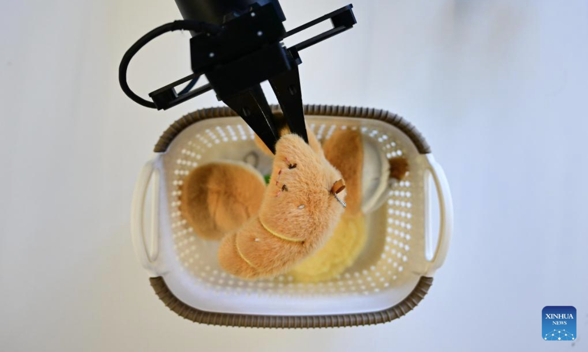 A humanoid robot, operated by a staff member for data collection purpose, fetches objects at Zerith, a robotics company, in Hefei, east China's Anhui Province, Nov. 25, 2025. In recent years, Hefei has been actively promoting the development of its intelligent robot industry. The city is now home to a full-chain industrial system for research, development and manufacturing of robotics that comprises 190 related enterprises. (Xinhua/Zhou Mu)