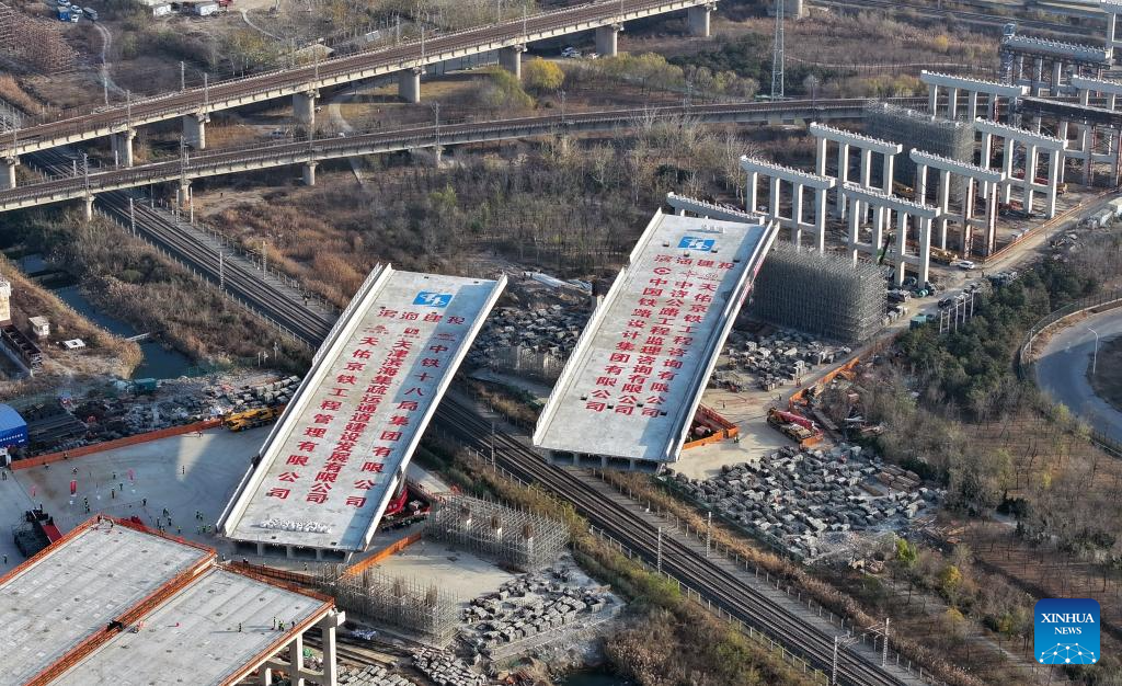 An aerial drone photo taken on Nov. 26, 2025 shows the construction site of twin swivel bridges of the Xinggang expressway in Tianjin, north China. The twin swivel bridges of the Xinggang expressway completed their rotation here on Wednesday. Two continuous beams, each weighing 14,000 tons, simultaneously turned clockwise by more than 60 degrees to pass over a railway.

The Xinggang expressway is a key transportation infrastructure project in support of the coordinated development of the Beijing-Tianjin-Hebei region. (Xinhua/Li Ran)