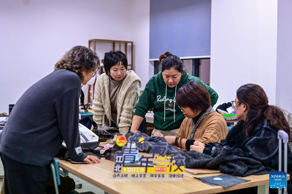 A teacher (2nd R) instructs citizens during a night-time fashion design class held at the youth activity center in Jiangbei District of Ningbo, east China's Zhejiang Province, Nov. 26, 2025. Starting from 2024, Jiangbei District in Ningbo has integrated educational and training resources from universities, hospitals, law firms and other enterprises and institutions in a night-time school project, offering courses in foreign languages, dance, music and fashion design, among others. It has enrolled more than 9,600 citizens by now. (Xinhua/Jiang Han)