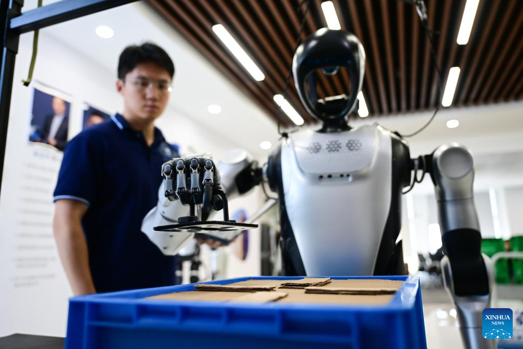 An engineer observes a humanoid robot grabbing a component at a laboratory of Leju Robotics in Hefei, east China's Anhui Province, Oct. 24, 2025. In recent years, Hefei has been actively promoting the development of its intelligent robot industry. The city is now home to a full-chain industrial system for research, development and manufacturing of robotics that comprises 190 related enterprises. (Xinhua/Zhou Mu)