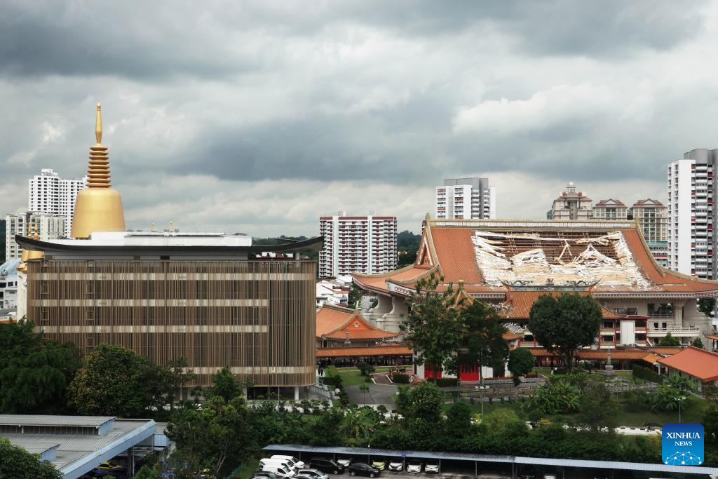 This photo shows the hole left by the fallen roof tiles of the Venerable Hong Choon Memorial Hall (R) of Singapore's Kong Meng San Phor Kark See Monastery on Nov. 27, 2025. (Photo by Then Chih Wey/Xinhua)