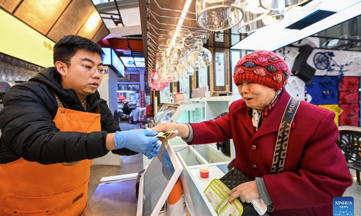 A senior woman pays at an ice-cream stall at Sanshui grocery market in Hexi District of Tianjin, north China, Nov. 25, 2025. With reading room, coffee outlet and grocery stalls brought under the same roof, Sanshui market, a traditional shopping place of more than 20 years old, was given a new life when it went through a refurbishing project and opened to business again in September this year.

Thanks to the newly added scenarios, Sanshui is no longer a mere source of daily necessities to the over 30,000 residents in 13 surrounding communities, but also a space to spend their leisure time in.

The renewal of this grocery market is just one of the many vivid examples of Hexi District's efforts to improve amenities for the local residents. To date, the district is home to 46 15-minute circles of daily convenience, where local residents are able to meet their daily needs within a 5-minute walk and access quality services within a 15-minute walk. (Xinhua/Zhao Zishuo)