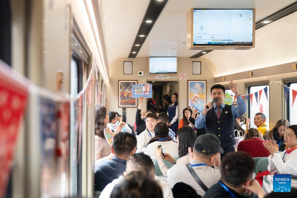A staff member performs for passengers onboard the Train Y783 on Nov. 26, 2025. Train Y783, an ice-and-snow themed tourism train, was launched at Harbin Railway Station and started a six-day trip on Wednesday. The train showcases the charm of northeastern China through themed decorations, tour guide services and interactive activities, in an effort to promote winter tourism and inject new vitality into ice and snow economy. (Xinhua/Zhang Tao)