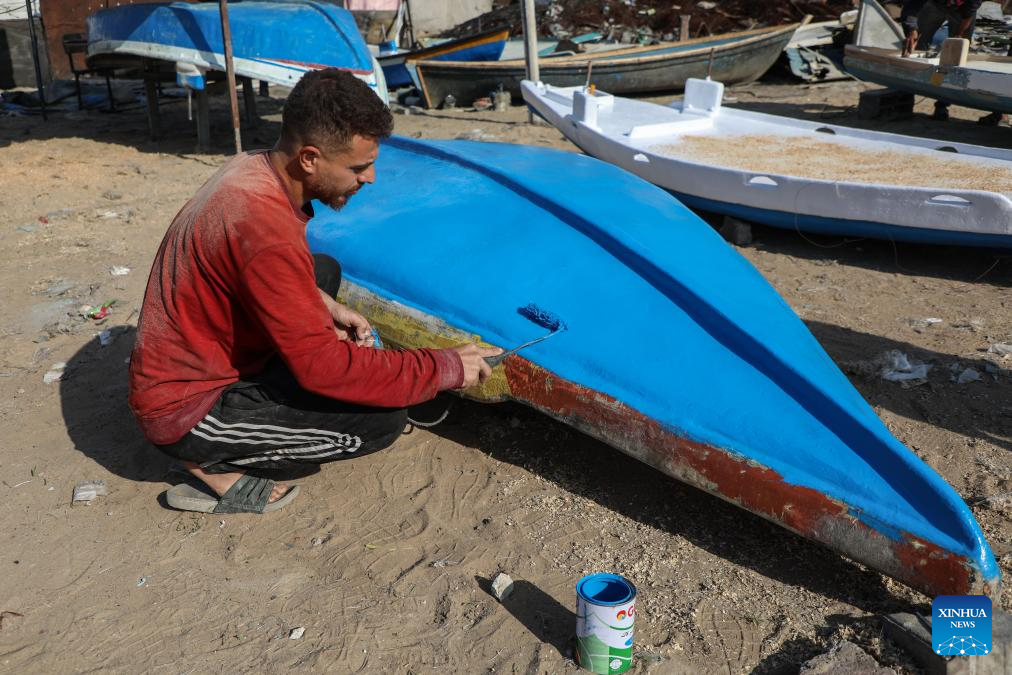 A Palestinian repairs a fishing boat destroyed during the Israeli war on the Gaza Strip, inside the seaport in west of Gaza City, on Nov. 27, 2025. (Photo by Rizek Abdeljawad/Xinhua)