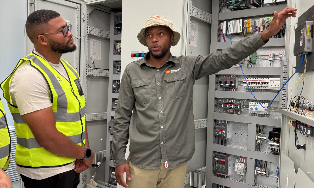 Deswin Basson (right) explains the controlling system for a wind power project to his colleague. Photo: Courtesy of Longyuan SA