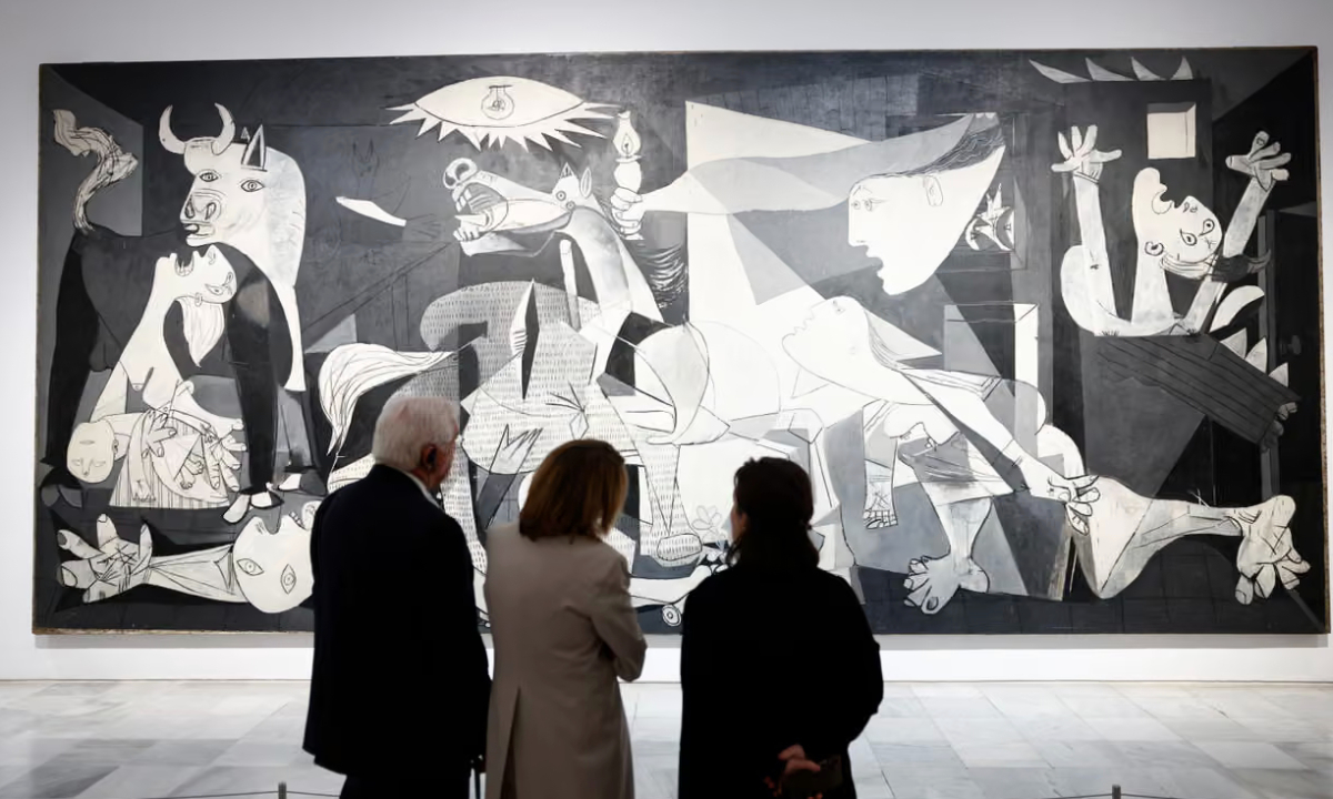 Frank-Walter Steinmeier (left) and the German first lady Elke Büdenbender (centre) look at Pablo Picasso’s painting Guernica at Reina Sofía Museum on Wednesday during a visit to Madrid. Photograph: Rodrigo Jimenez/EPA