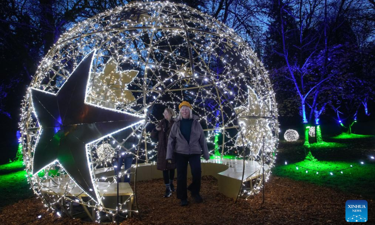 People enjoy the light installations at VanDusen Botanical Garden during the annual Festival of Lights in Vancouver, British Columbia, Canada, Nov. 28, 2025. The annual holiday event kicked off here on Friday, with over 1 million lights transforming the garden into a dazzling holiday spectacle. (Photo by Liang Sen/Xinhua)