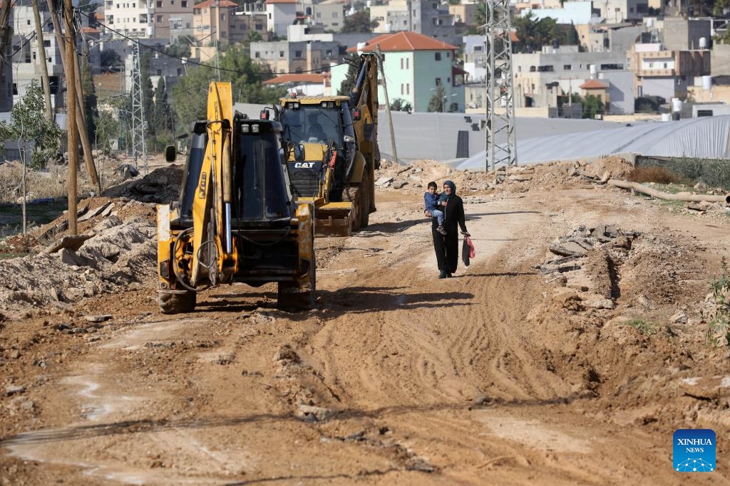 A Palestinian woman, holding a child in her arm, walks along a destroyed street in the town of Tammun, south of Tubas in the West Bank, on Nov. 28, 2025.

Israeli security forces and settlers have killed 1,030 Palestinians in the occupied West Bank, including East Jerusalem, since Oct. 7, 2023, the United Nations Office of the High Commissioner for Human Rights (OHCHR) has verified, a UN spokesperson said here Friday.

Among the fatalities were 223 children, Jeremy Laurence, spokesperson for the OHCHR, told a regular UN press briefing in Geneva. (Photo by Nidal Eshtayeh/Xinhua)