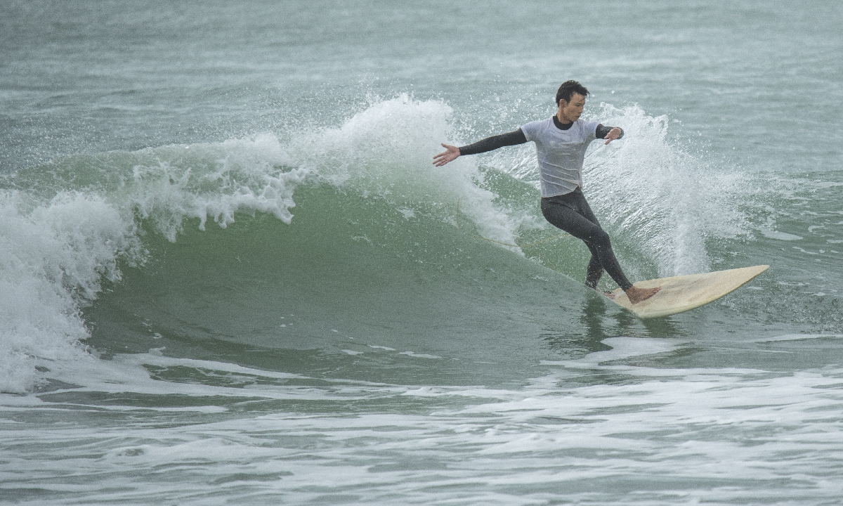 A contestant surfs in the rain at Riyue Bay in Wanning, South China's Hainan Province on November 30, 2025. A total of 100 surfers from across the province are participating in the competition. Photo: VCG