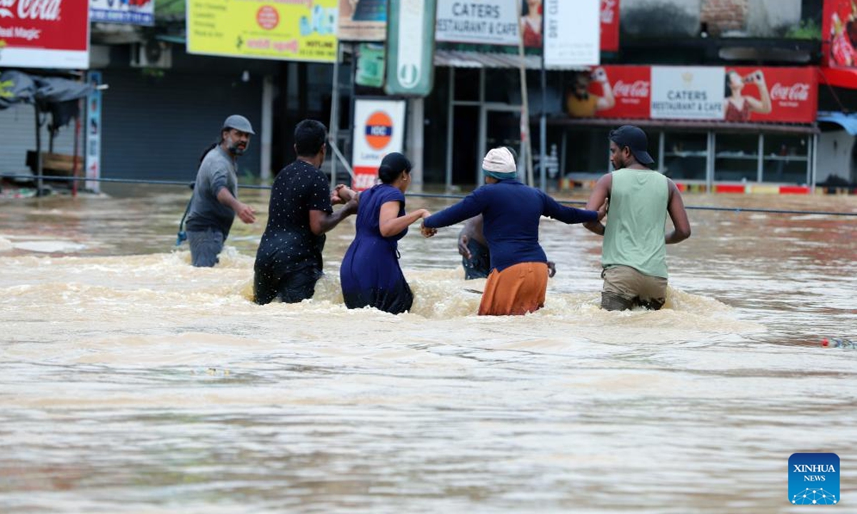 People evacuate by wading through floodwater after heavy rains on the outskirts of Colombo, Sri Lanka, on Nov. 29, 2025. Sri Lankan President Anura Kumara Dissanayake has declared a State of Public Emergency effective on Friday, as the country confronts one of its worst weather-related disasters in recent years. (Photo by Ajith Perera/Xinhua)