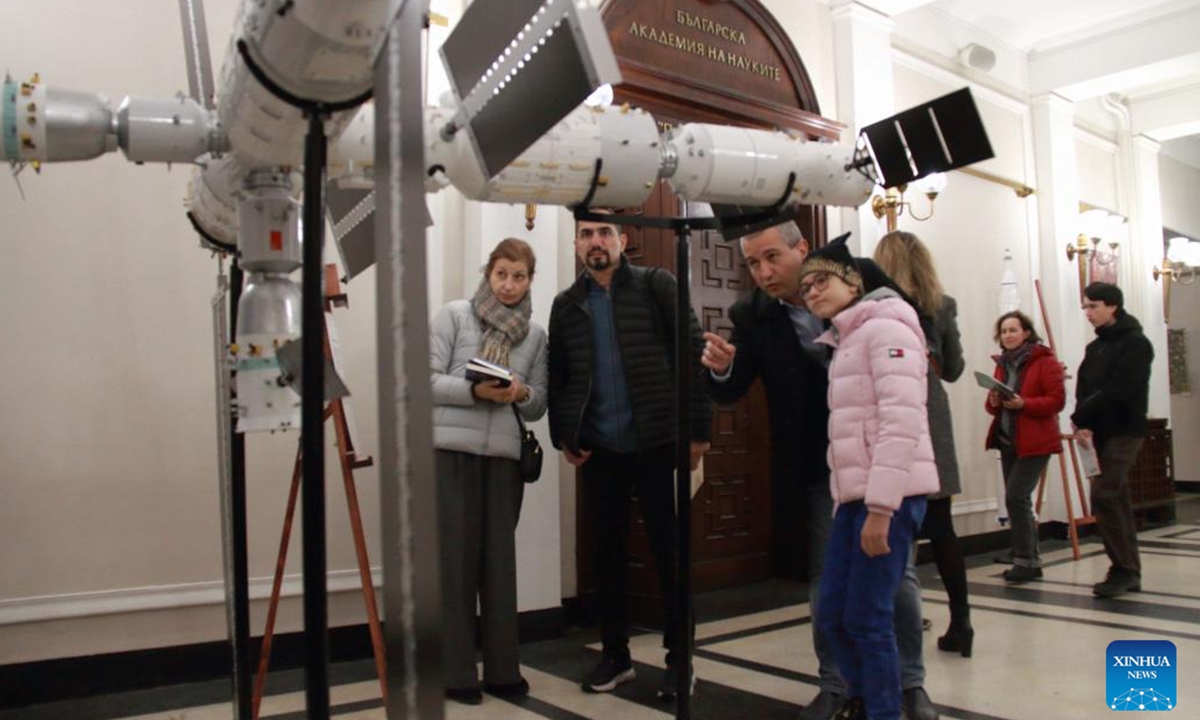 Visitors view a large-scale model of the Chinese space station as they attend a screening of Blue Planet Outside the Window or SHENZHOU 13 in Sofia, Bulgaria, Nov. 30, 2025. Blue Planet Outside the Window or SHENZHOU 13, China's first space documentary filmed in space, was screened here on Sunday, showcasing the wonders of aerospace technology. The event was co-hosted by the Chinese Embassy in Bulgaria and the Space Research and Technology Institute of the Bulgarian Academy of Sciences.  (Photo by Marian Draganov/Xinhua)